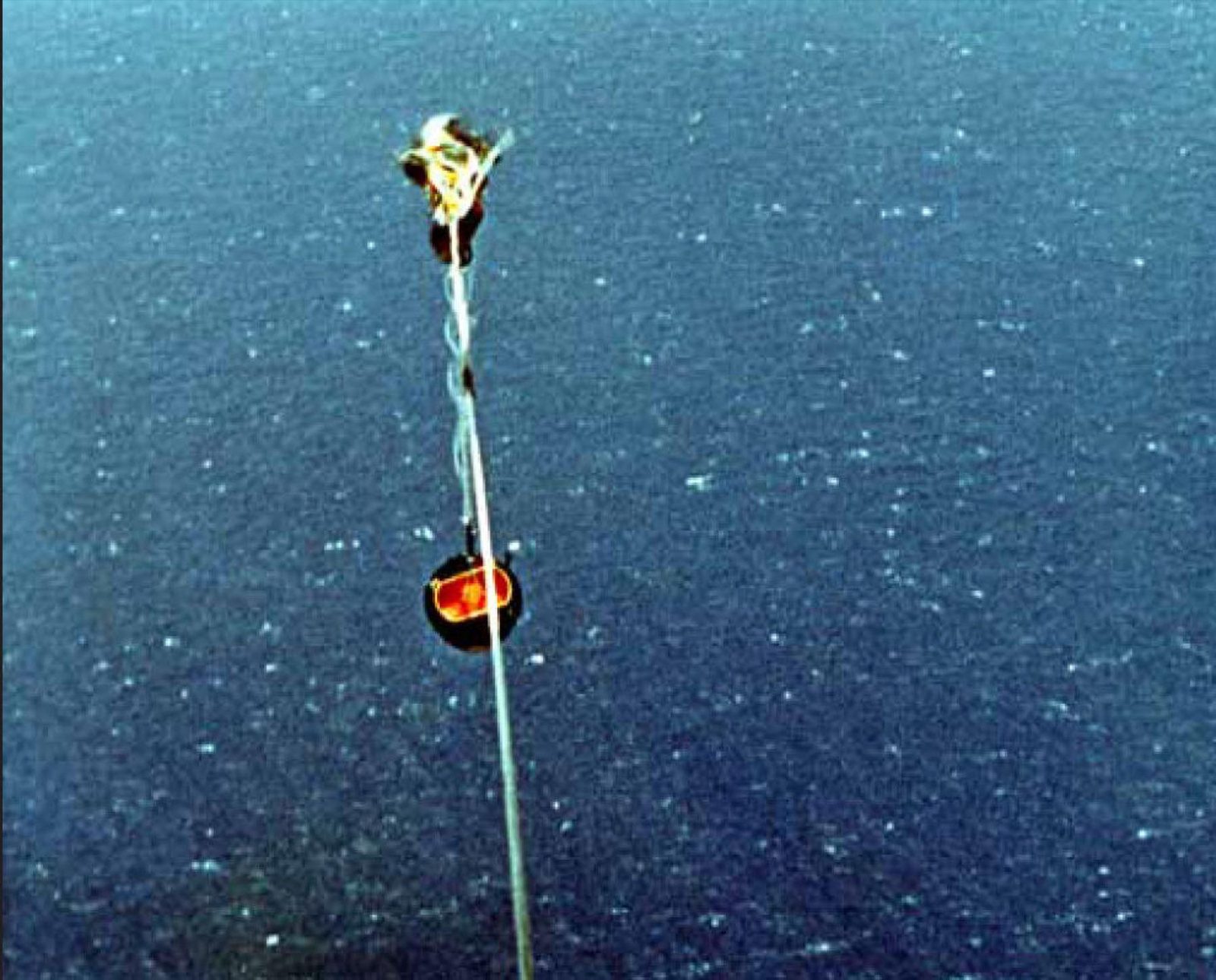 A C-119 OF THE 6593D TEST SQUADRON SNAGS THE DISCOVERER 14 FILM CAPSULE IN MIDAIR OVER THE PACIFIC, AUGUST 19, 1960. U.S. AIR FORCE PHOTO. (PUBLIC DOMAIN)